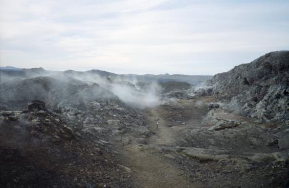 A path running through the lava fields, with steam rising from the cracks in the ground